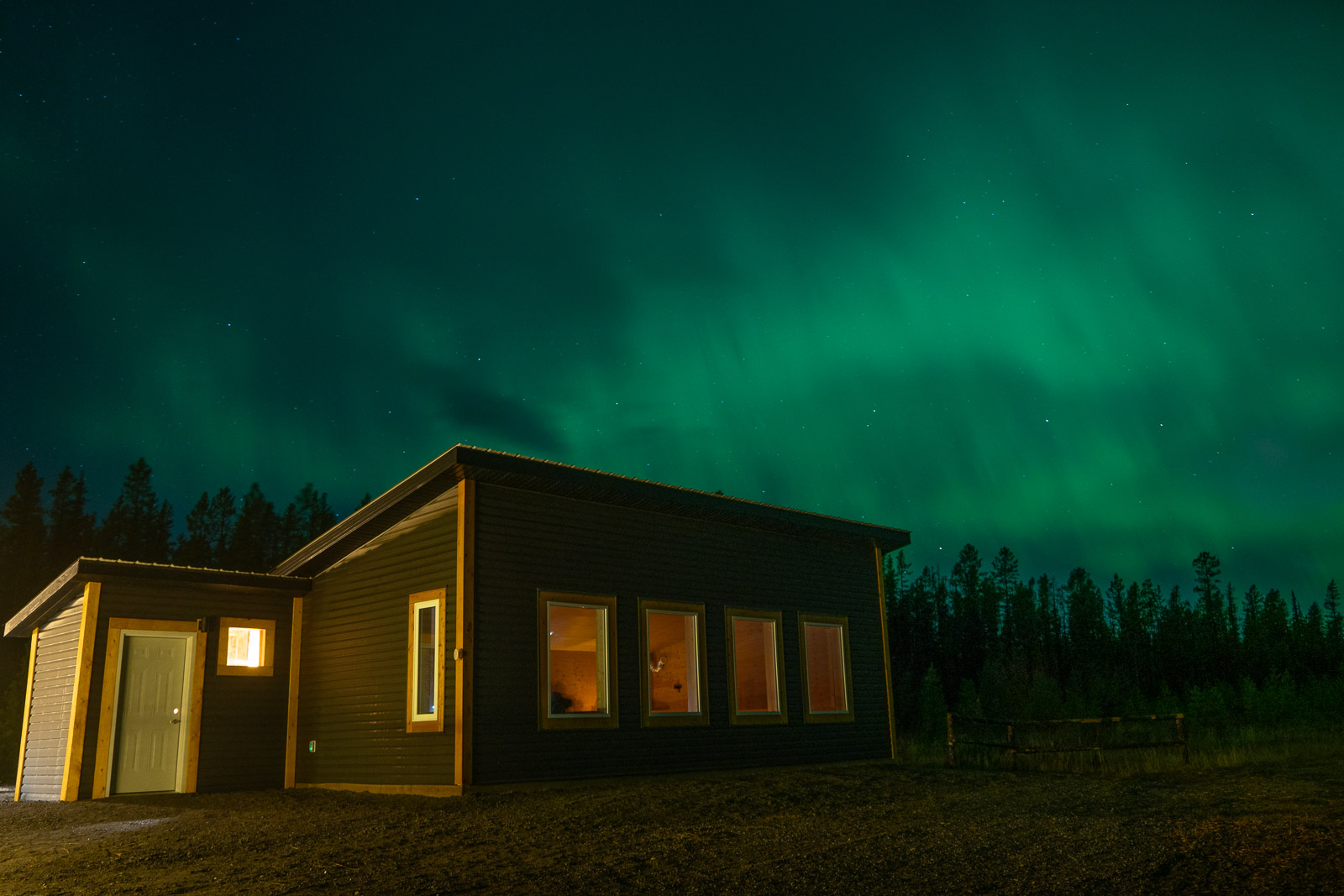 a cabin with green lights in the sky
