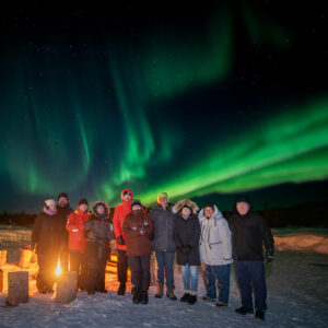 Group under the aurora, by the fire
